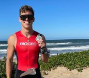 Olympian Sean Gunn poses on a beach with a medal