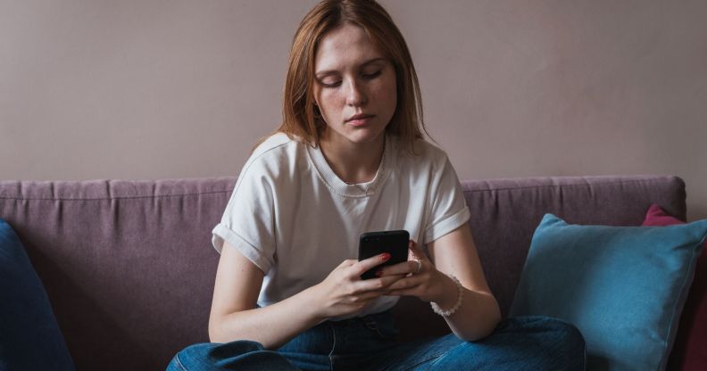 Stock image of a woman on her phone to illustrate an article about Meta