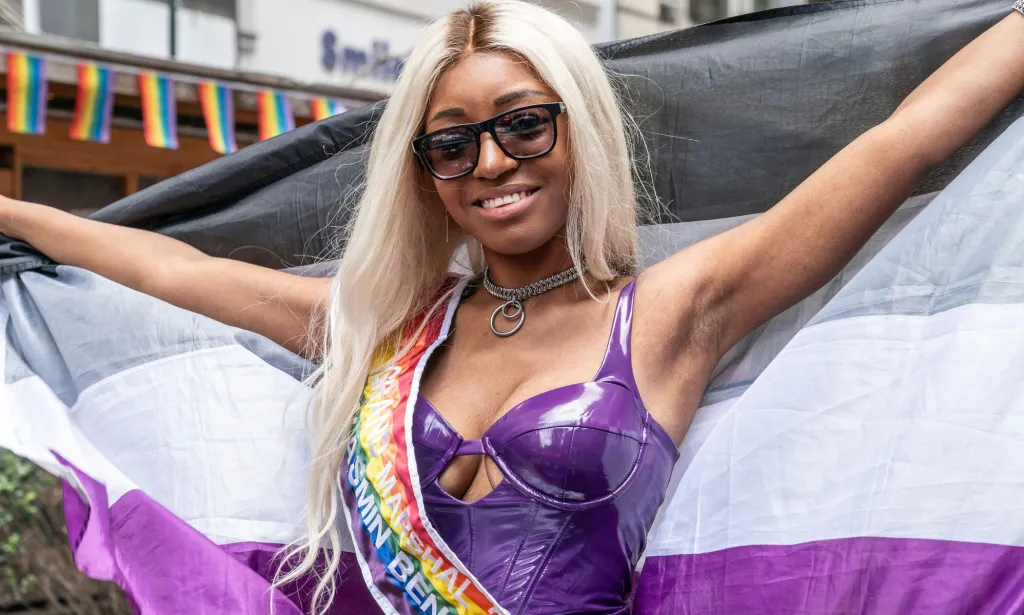 Yasmin Benoit, pictured holding up an asexual Pride flag.