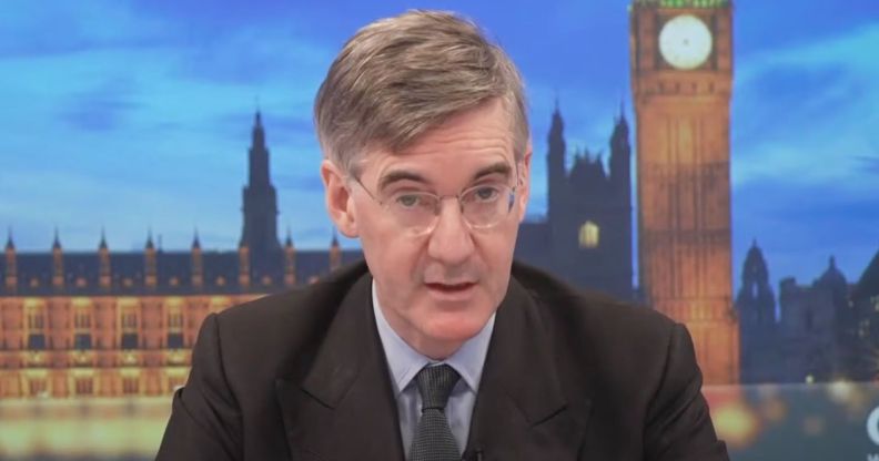 Tory MP Jacob Rees-Mogg sits at the desk as he presents on GB News