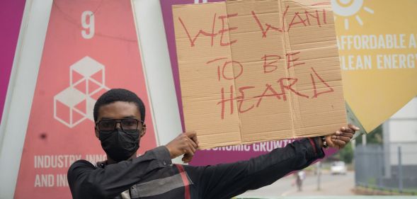 LGBTQ+ activist Prince Frimpong holds up a sign reading 'we want to be heard' while protesting anti-LGBTQ+ sentiment in Ghana