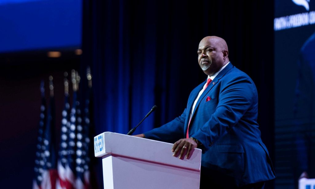 North Carolina lieutenant governor Mark Robinson wears a suit and tie as he stands at a podium during an event