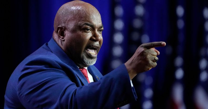 North Carolina Republican governor candidate Mark Robinson wears a suit and tie as he points somewhere off camera during a speech