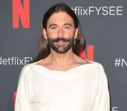 Queer Eye star Jonathan Van Ness looks towards the camera while wearing a white top
