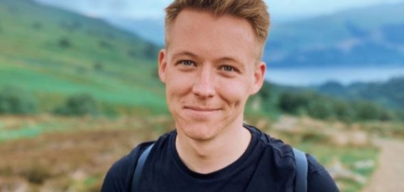 A picture of late BBC Scotland presenter and author Nick Sheridan wearing a black shirt and backpack while walking around outside
