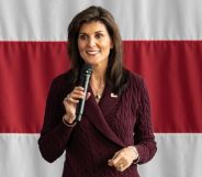 Republican politician Nikki Haley, who was running in the 2024 presidential election, speaks into a microphone while standing in front of the red and white stripes of the USA flag