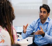 A doctor speaking to a patient in a medical room.