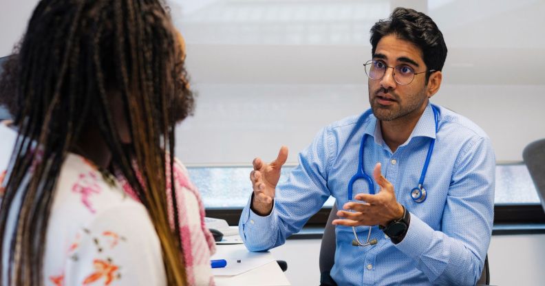 A doctor speaking to a patient in a medical room.