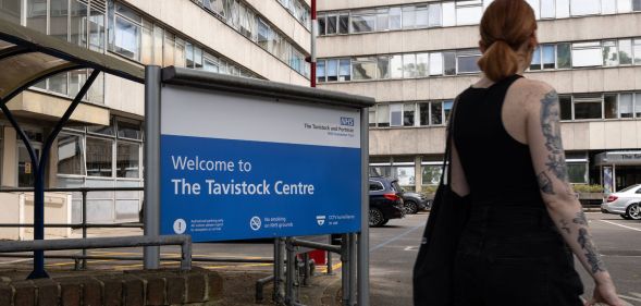 A person walking past the Tavistock Centre sign.