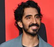 Dev Patel smiling during a red carpet event at the Monkey Man premiere.