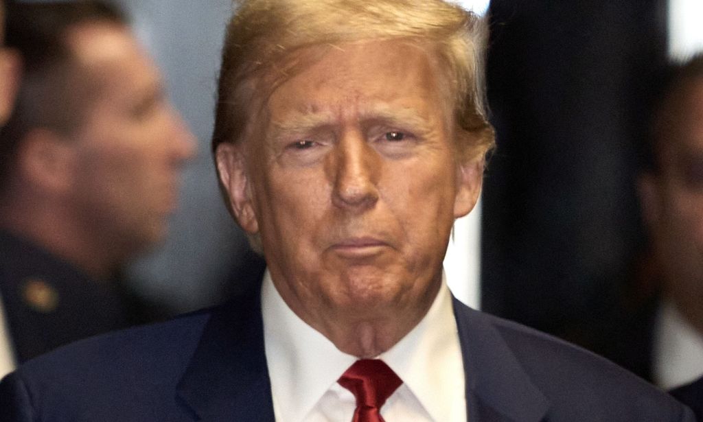 Donald Trump walking through a crowded street.