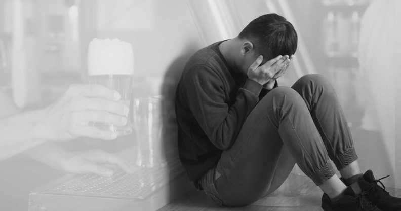 a man with his head in his hands, a bar in the background