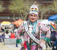 A Two Spirit person dances at an event in elaborate traditional dress