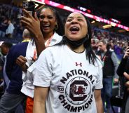 Image shows basketball coach Dawn Staley celebrating a victory in a stadium