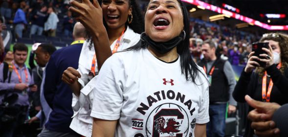 Image shows basketball coach Dawn Staley celebrating a victory in a stadium