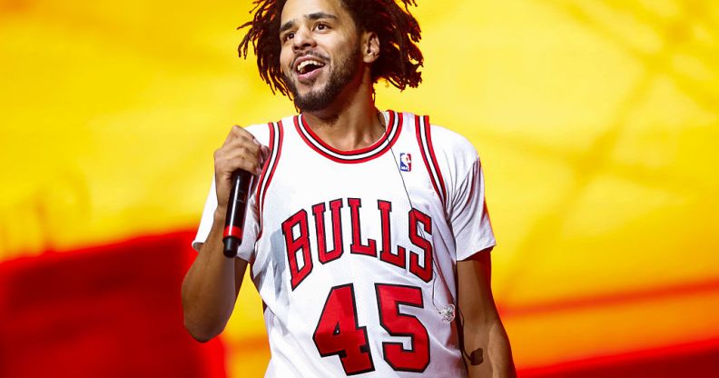 Recording artist J. Cole performs on day one of Lollapalooza on July 28, 2016 in Chicago, Illinois. He is wearing a bulls T-shirt and holding a microphone.