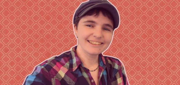 This is an image of a non-binary person. They are wearing a plaid shirt and a hat.