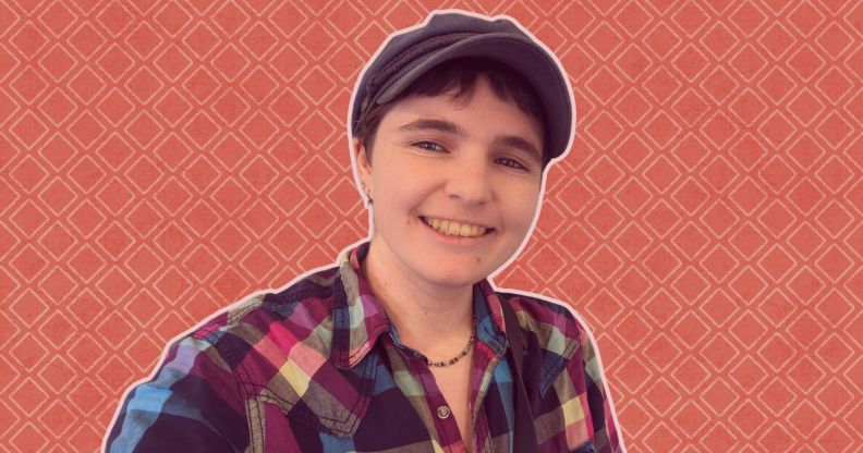This is an image of a non-binary person. They are wearing a plaid shirt and a hat.