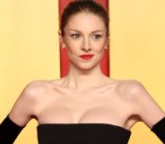 Hunter Schafer with her hands on her hips posing at a Vanity Fair red carpet event.