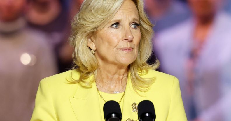 Jill Biden, wearing a yellow suit, speaks into a microphone.