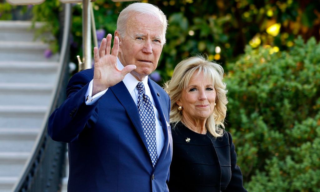Joe Biden and Jill Biden waving to press as they walk by.