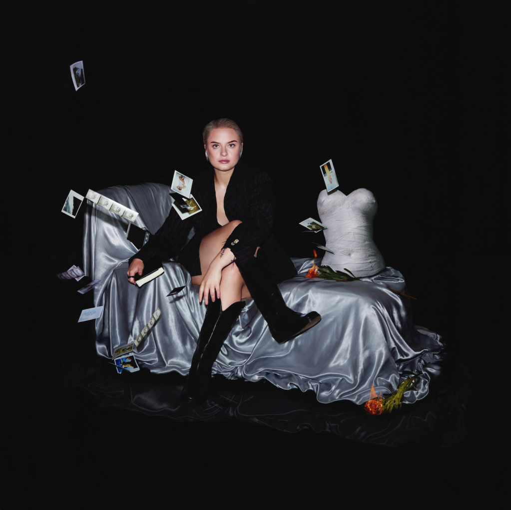 The EP cover for Lapsley's A Guilty Heart Can Never rest featuring the singer dressed in black sat on a grey bed.