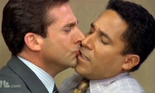 Michael Scott awkwardly kisses Oscar the accountant in a scene from The Office