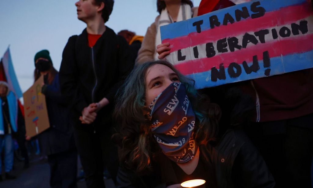 Activists holding signs of trans liberation during a protest.