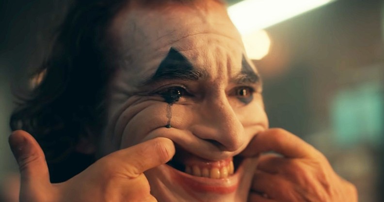 The Joker forcing himself to smile but crying