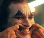 The Joker forcing himself to smile but crying