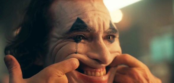 The Joker forcing himself to smile but crying