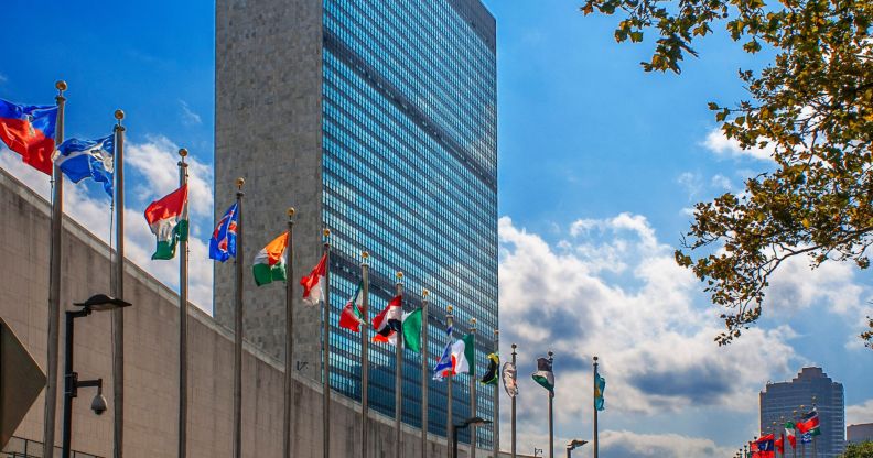 a picture of several county flags infront of the United Nations building in New York.