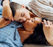 Stock image of two women kissing while lying on a sofa