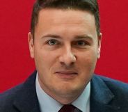 Wes Streeting at a Labour conference in front of a red background.