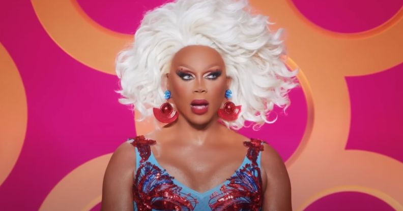 A screenshot of RuPaul watching a lip-sync during All Stars 8. She is wearing a red and blue dress and looks shocked.