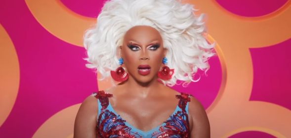 A screenshot of RuPaul watching a lip-sync during All Stars 8. She is wearing a red and blue dress and looks shocked.