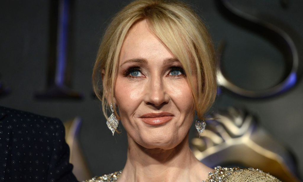 Harry Potter author JK Rowling stares somewhere off camera while wearing a gold dress and matching jewellery