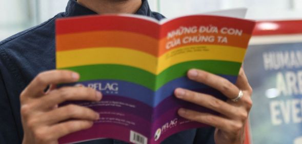 In this picture taken on May 17, 2021, candidate for Vietnam's National Assembly Luong The Huy poses with a book about LGBT issues in his office in Hanoi. - As an LGBTI activist, legal whizz kid and Vietnam's first openly gay candidate running for a seat in its rubber-stamp parliament, Luong The Huy is determined to lead long-lasting change for the country's marginalised communities. - TO GO WITH Vietnam-homosexuality-parliament-politics, INTERVIEW by Tran Thi Minh Ha (Photo by Nhac NGUYEN / AFP) / TO GO WITH Vietnam-homosexuality-parliament-politics, INTERVIEW by Tran Thi Minh Ha (Photo by NHAC NGUYEN/AFP via Getty Images)