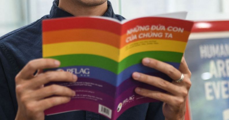 In this picture taken on May 17, 2021, candidate for Vietnam's National Assembly Luong The Huy poses with a book about LGBT issues in his office in Hanoi. - As an LGBTI activist, legal whizz kid and Vietnam's first openly gay candidate running for a seat in its rubber-stamp parliament, Luong The Huy is determined to lead long-lasting change for the country's marginalised communities. - TO GO WITH Vietnam-homosexuality-parliament-politics, INTERVIEW by Tran Thi Minh Ha (Photo by Nhac NGUYEN / AFP) / TO GO WITH Vietnam-homosexuality-parliament-politics, INTERVIEW by Tran Thi Minh Ha (Photo by NHAC NGUYEN/AFP via Getty Images)