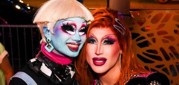 A photo of Drag Race season 16 contestants Dawn and Amanda Tori Meating in drag smiling.