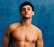 Tom Daley posing in Team GB blue swim trunks