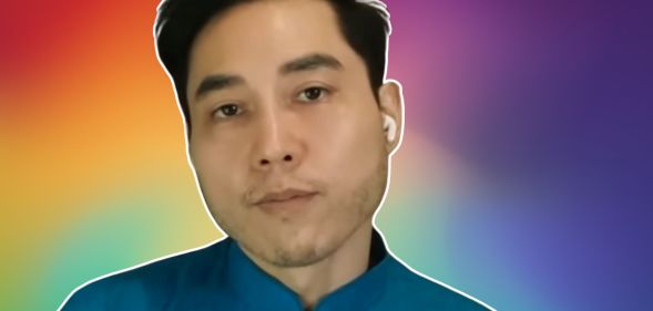 A screenshot of Andy Ngo infront of a rainbow background.