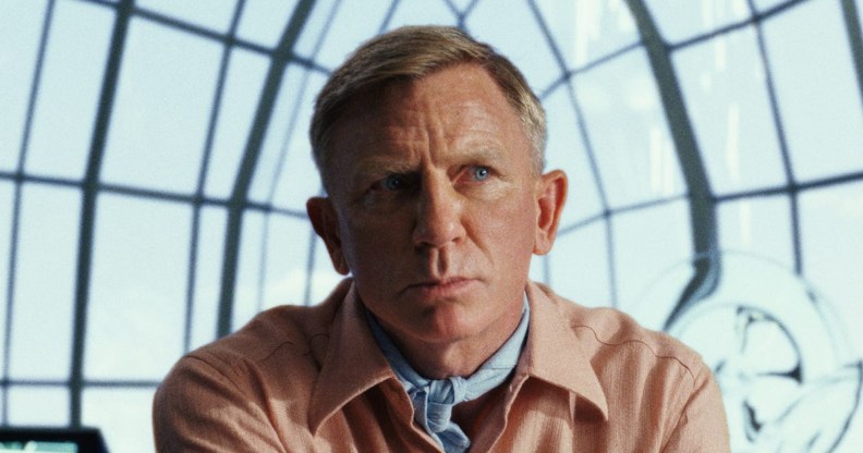 Daniel Craig in a peach suit against a window