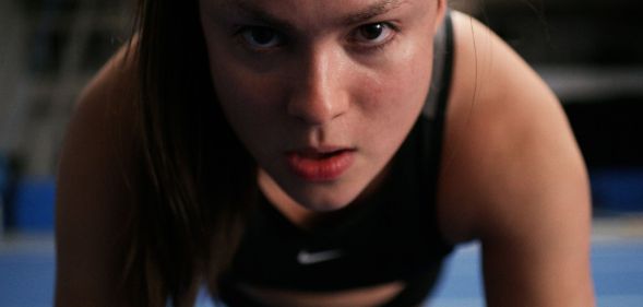 Devery Jacobs does a push up in a still from cheerleading film Backspot.