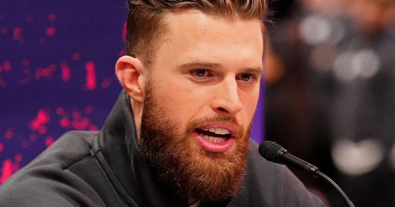 Harrison Butker speaking into a microphone during an NFL press conference.