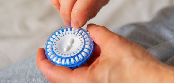 A person holding a hormone capsule.