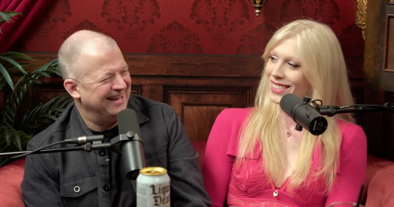Jim and Nikki Norton sat on a red podcast sofa, both laughing