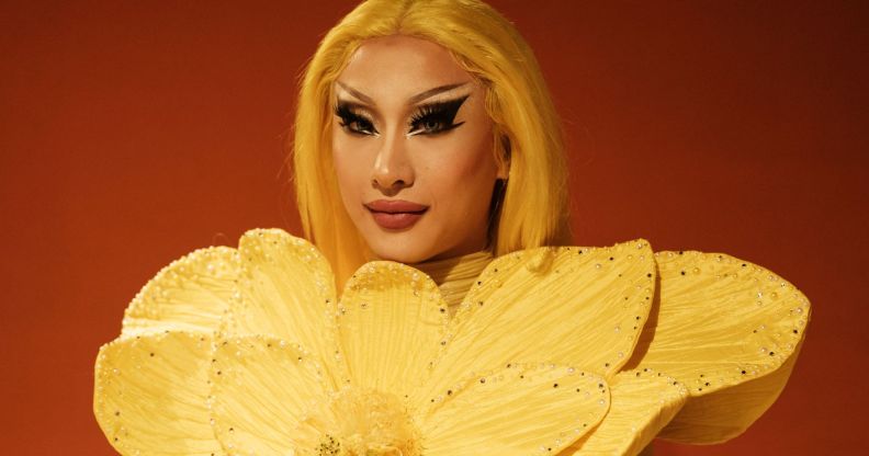 Drag Race winner Nymphia Wind in a yellow flower outfit.