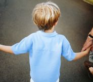 Two parents holding the hand of a child.