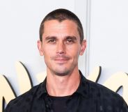 Antoni Porowski with a shaved head and black top and jacket.